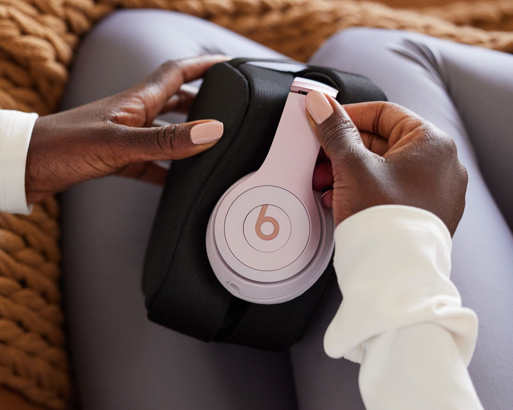 Person holding a pair of Solo 4 headphones