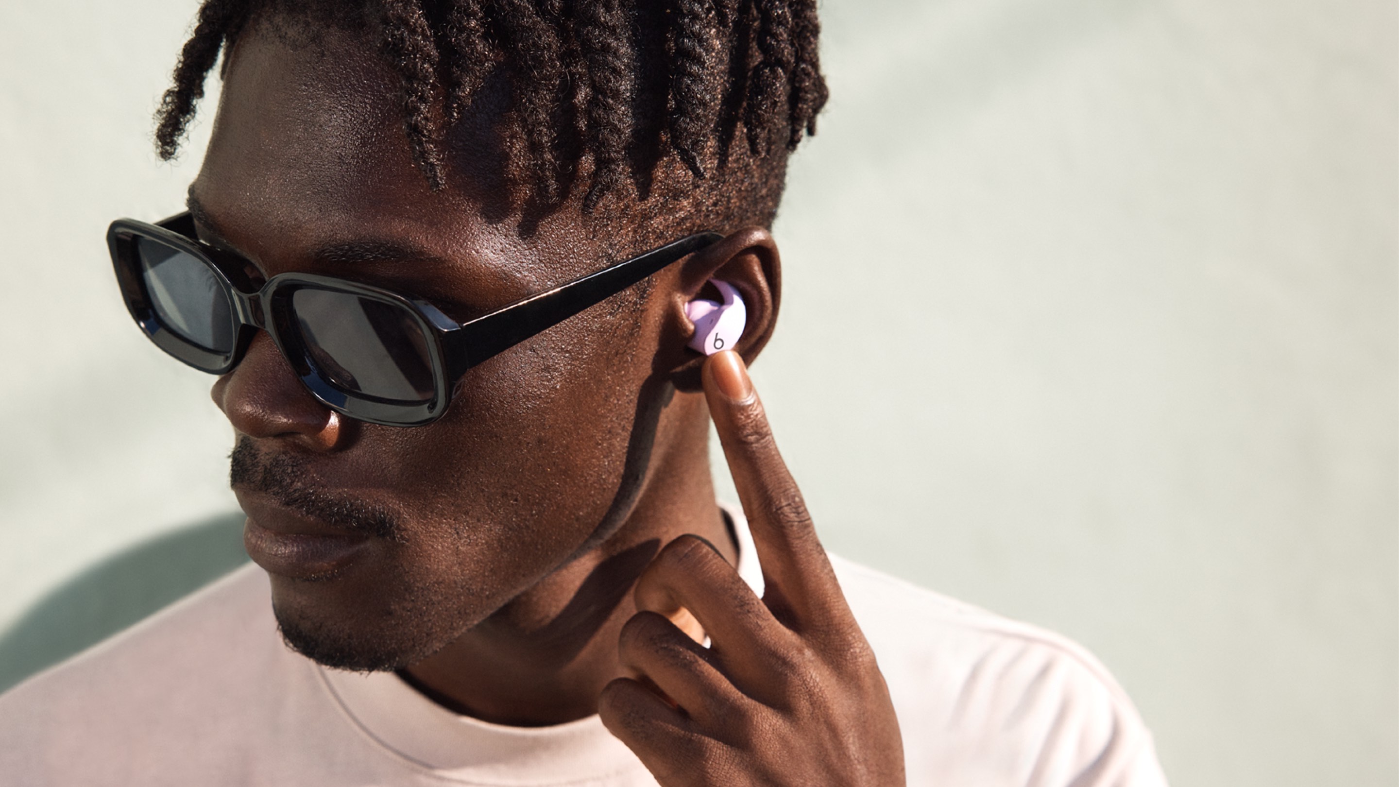 Person wearing Stone Purple Beats Fit Pro earbuds outside
