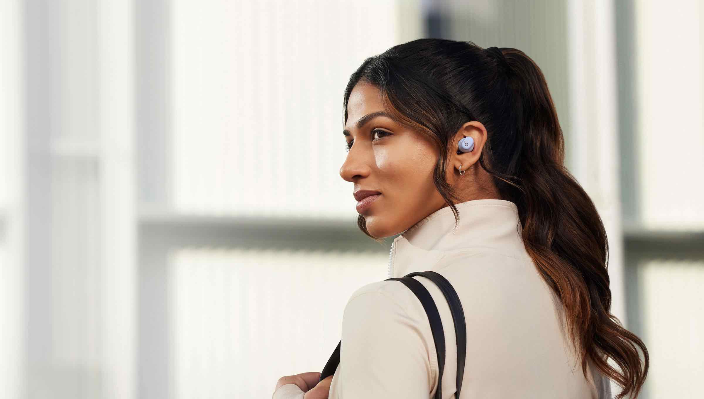 Woman wearing Solo Buds taking a call.