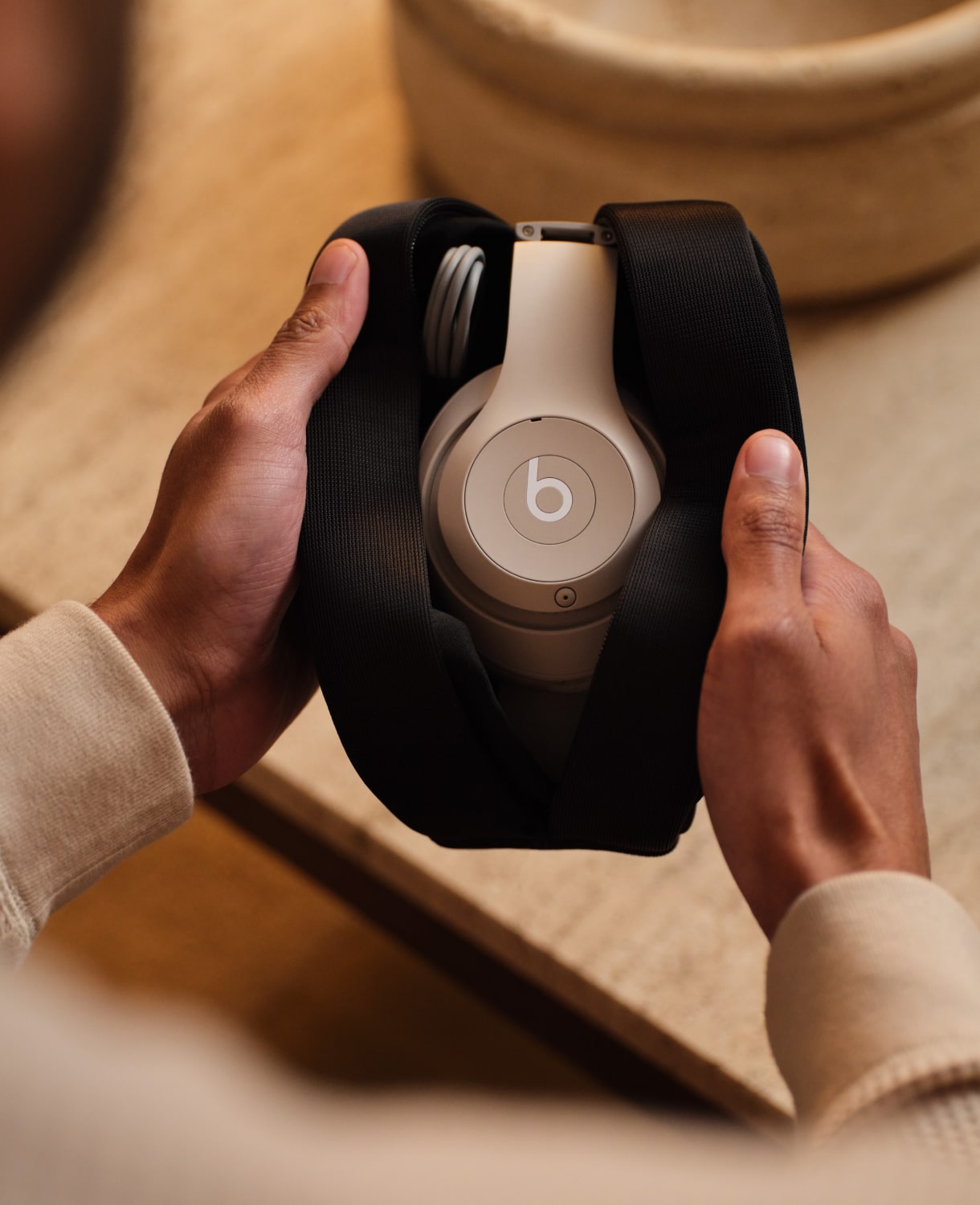 Person holding Beats Studio Pro Wireless Headphones in the color Sandstone