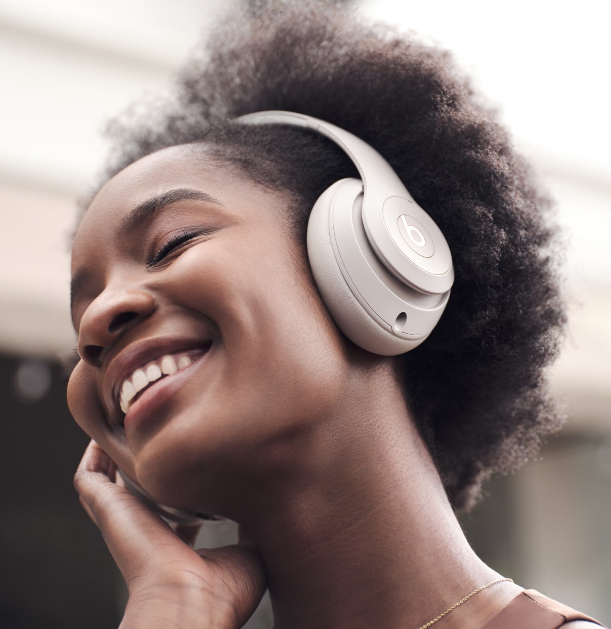 Person wearing Beats Studio Pro Wireless Headphones in the color Sandstone